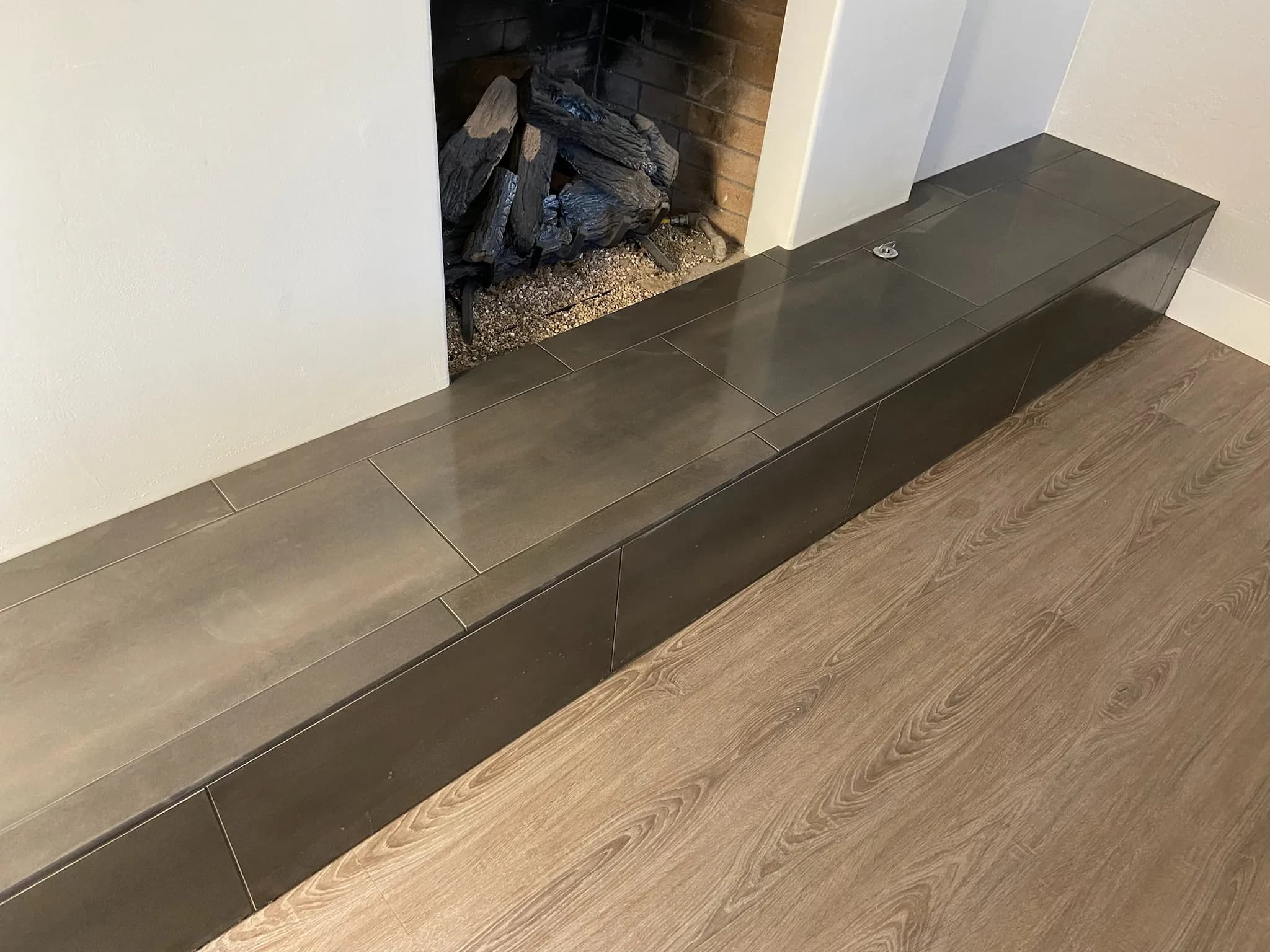 Modern fireplace with large-format tile hearth extending across the floor