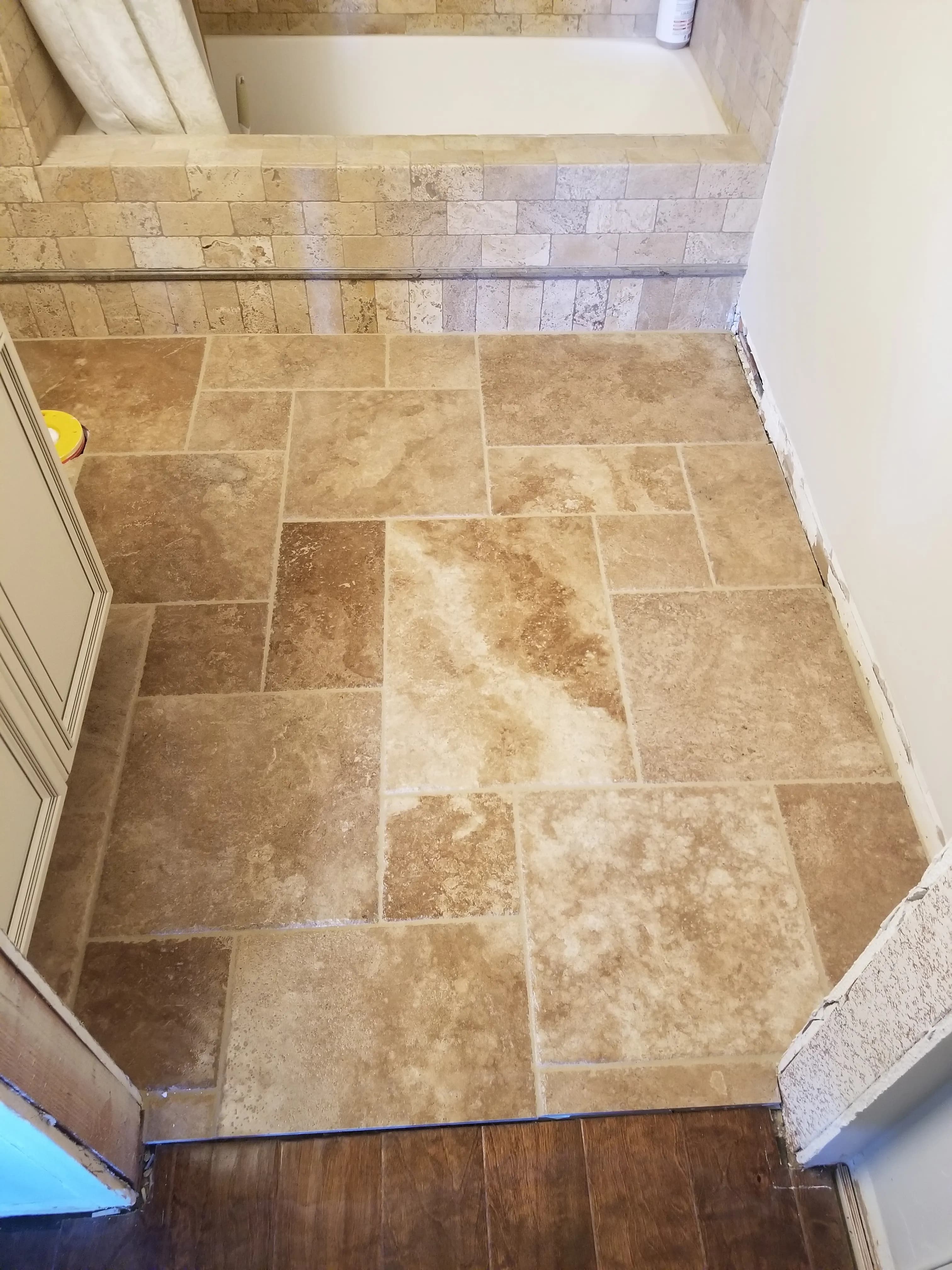 Tan travertine-look tile floor with rectangular tiles and natural stone variation