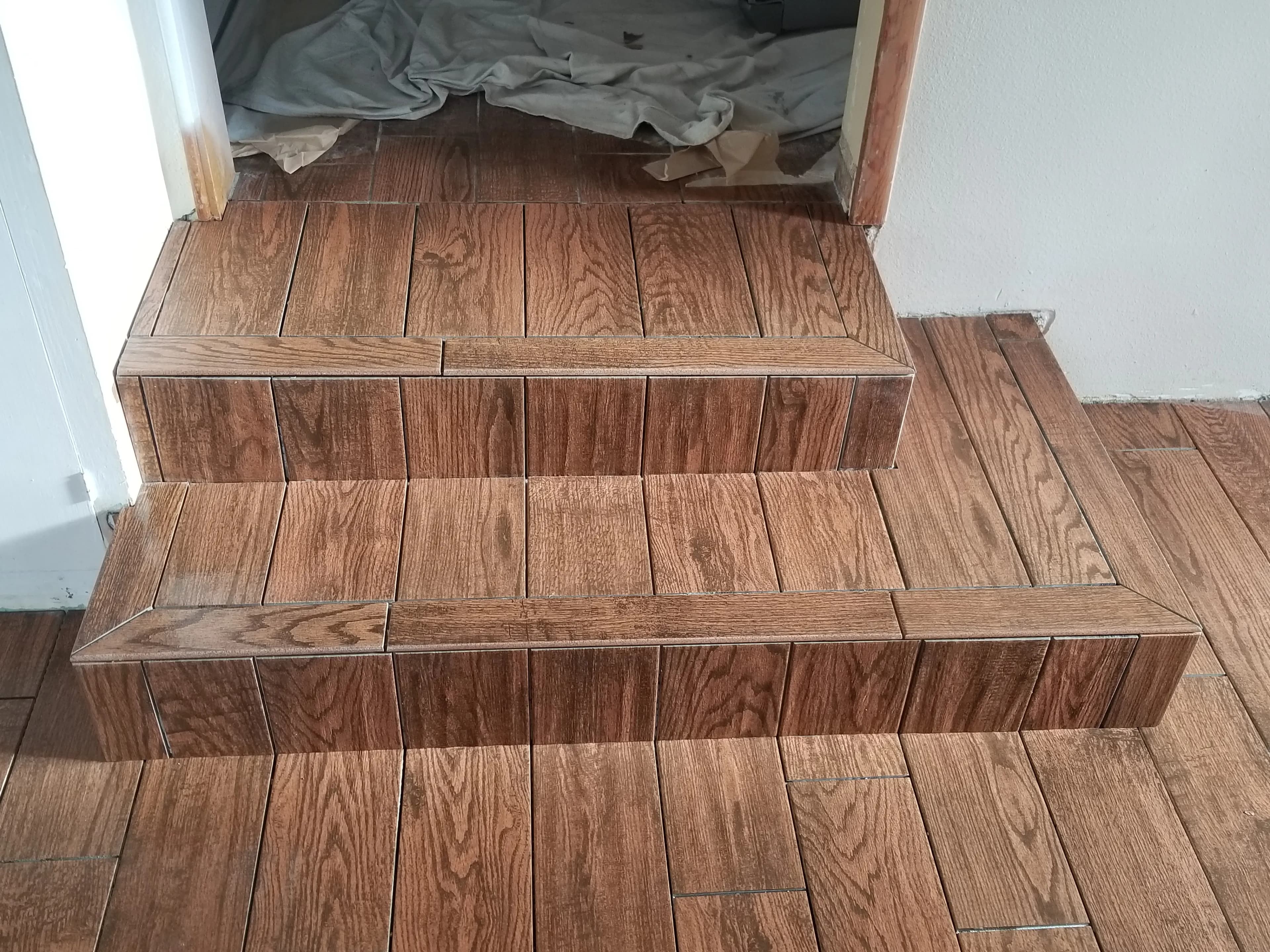 Wood-look tile installed on stair treads and risers with matching landing