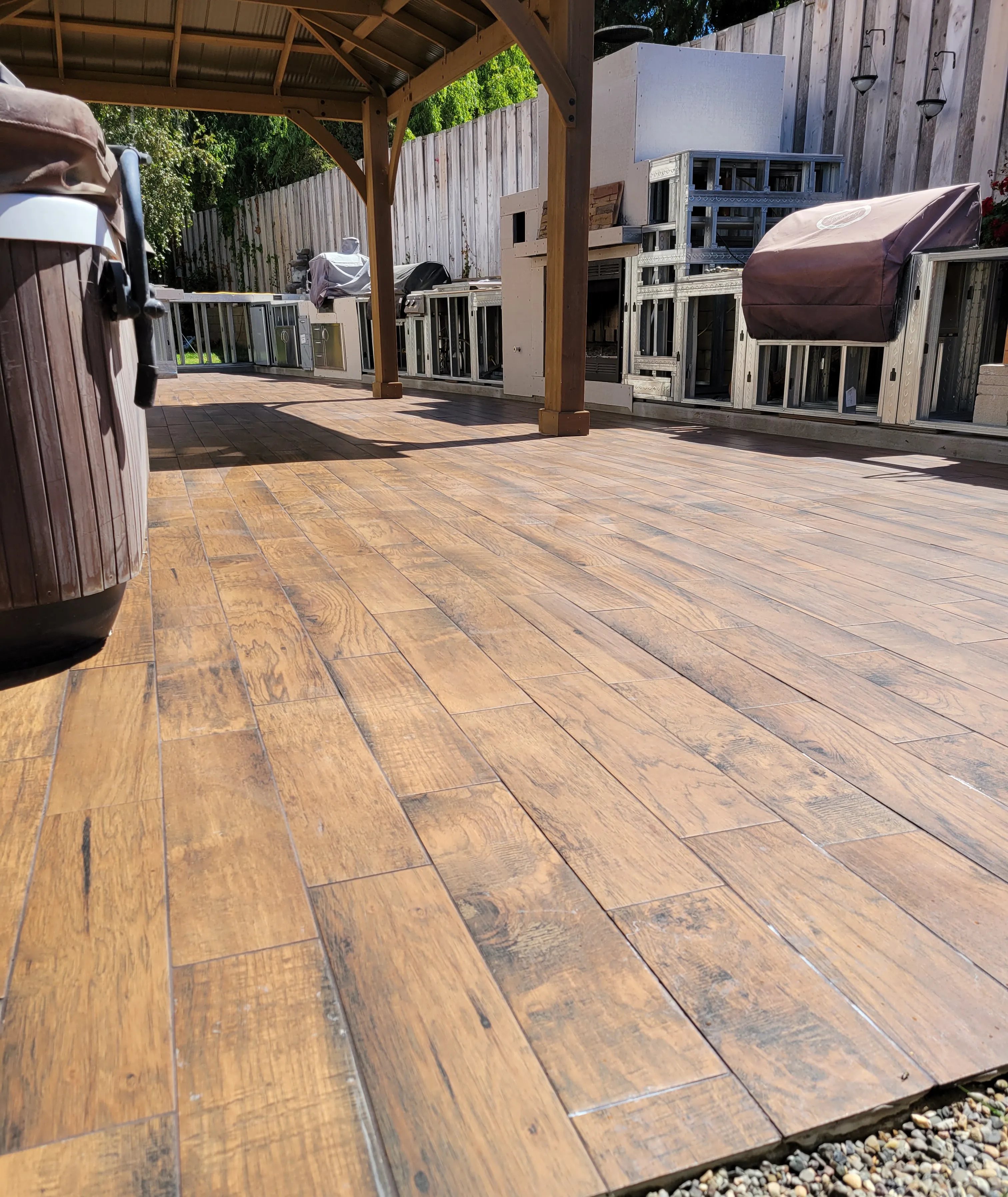 Outdoor patio with wood-look tile planks installed under a covered structure
